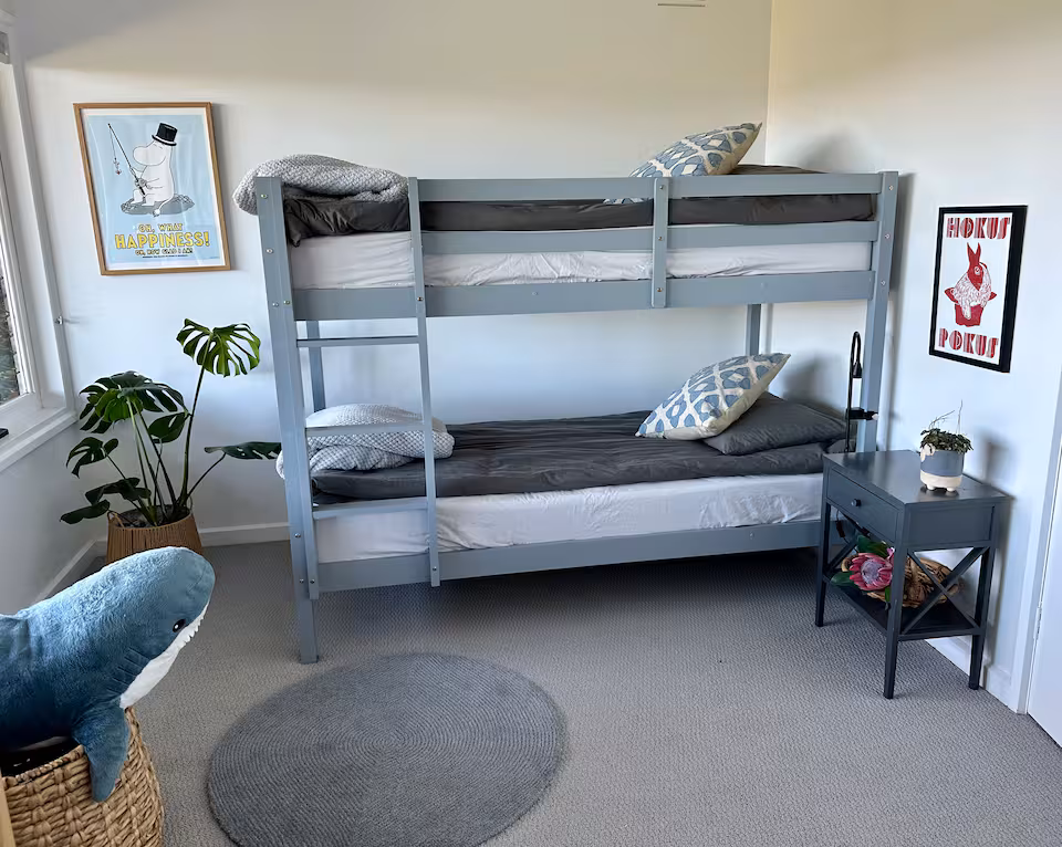Bunk room with timber bunk beds, artwork and soft toys